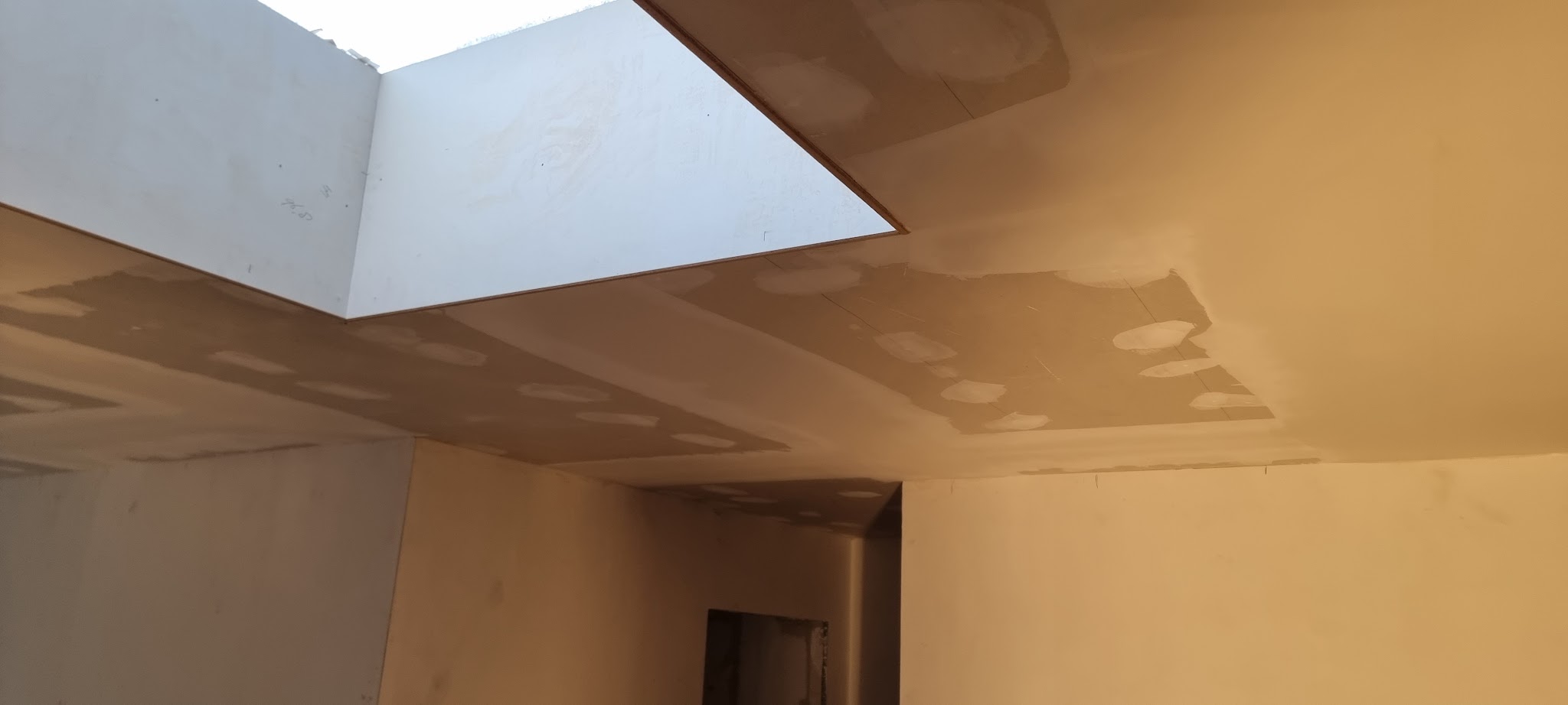 Gevuld gipsplafond met een lichtkoepel boven een gang